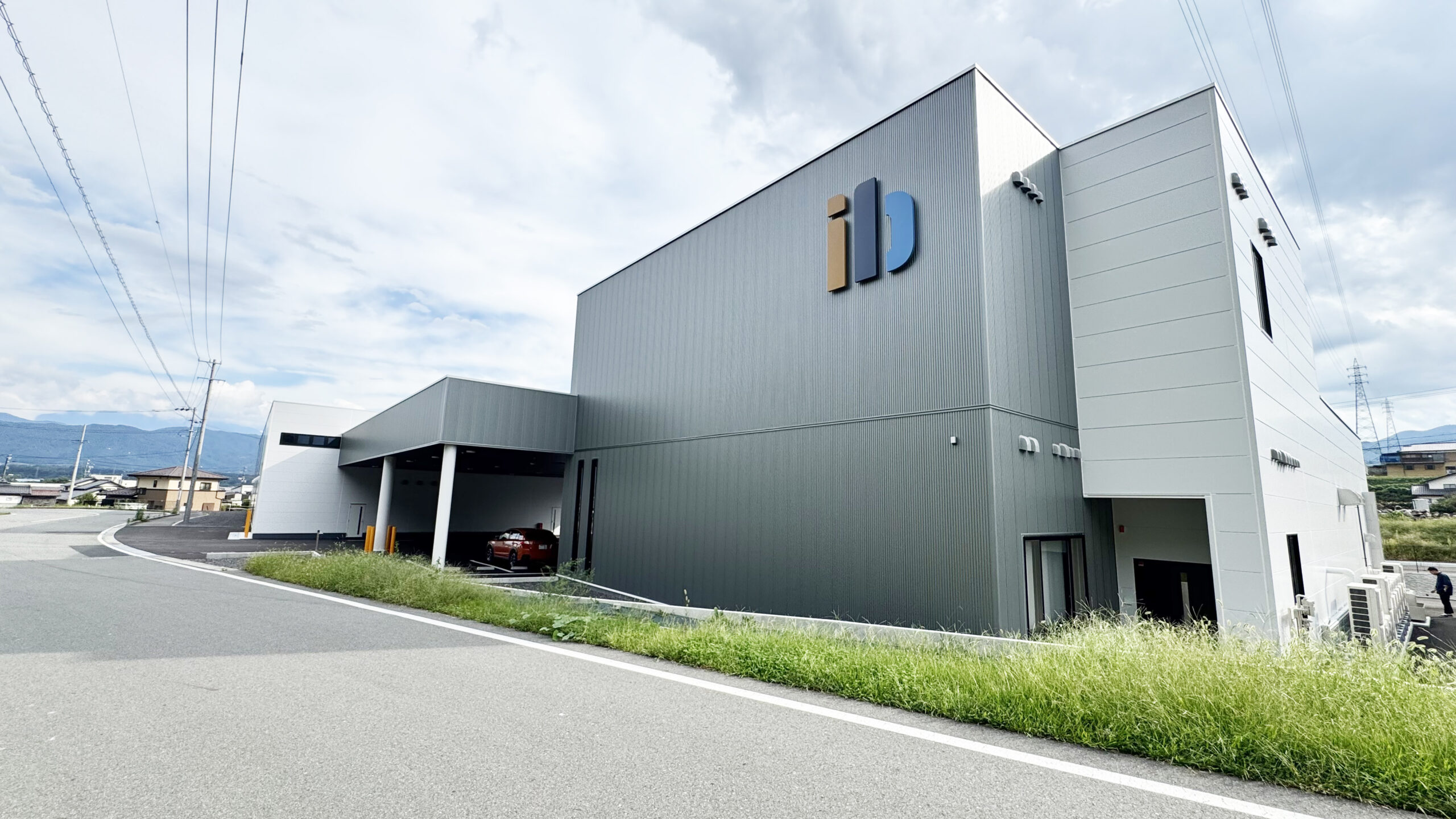 アイ.ビイ自動車工業株式会社の新ロゴ｜青空に映える新しい社屋